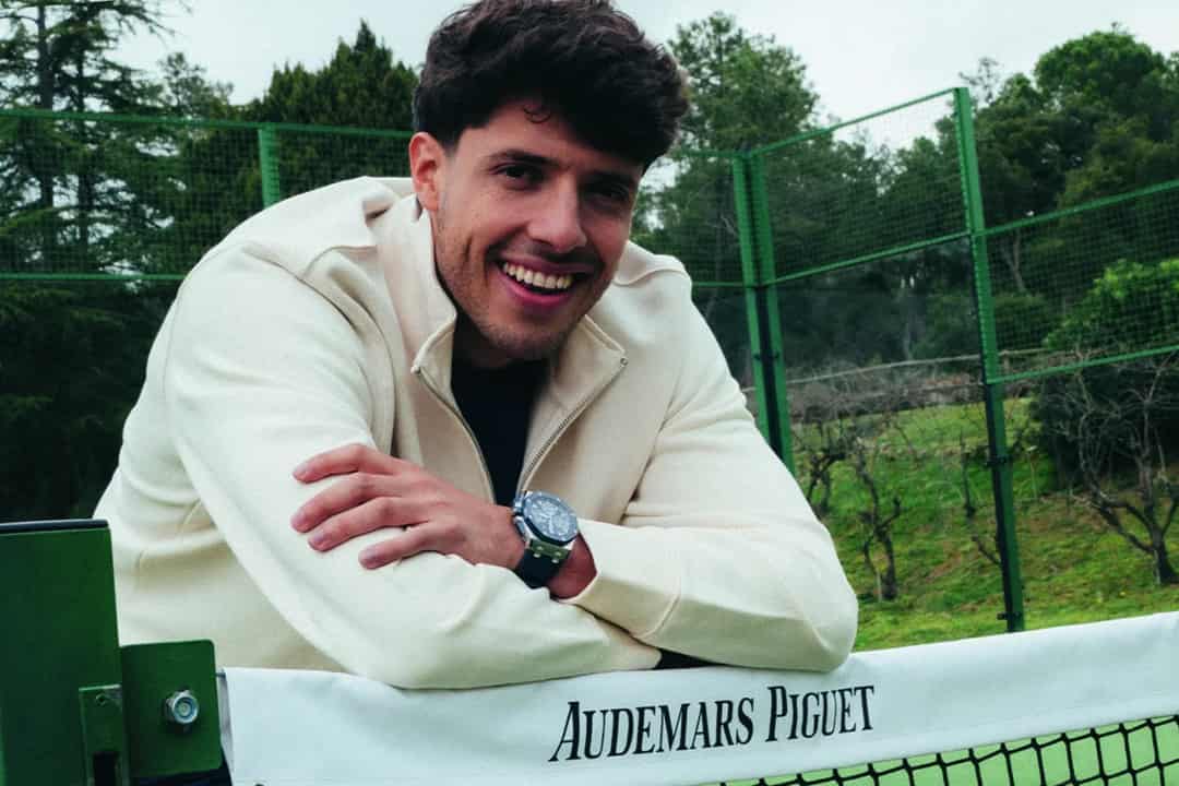 Agustin Tapia leunt tegen een padelbaan-net met Audemars Piguet branding
