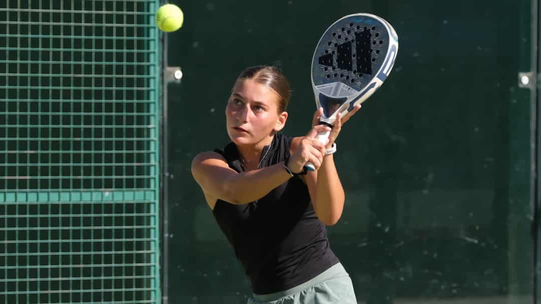Jonge speelster slaat een backhand tijdens een FIP Promises-jeugdtoernooi