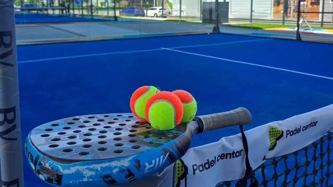 Padelracket en ballen op het net van een blauwe outdoor padelbaan van Padel Centar in Belgrado