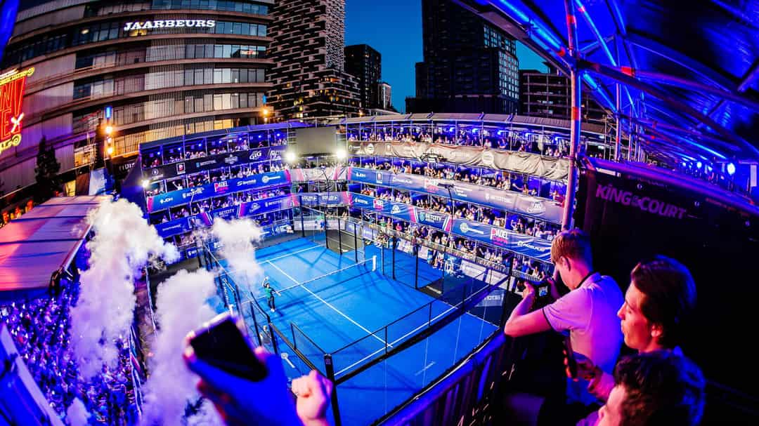 Het tijdelijke padelstadion van Padel Copa op het Jaarbeursplein in Utrecht bij avondlicht, met volle tribunes rond de baan.