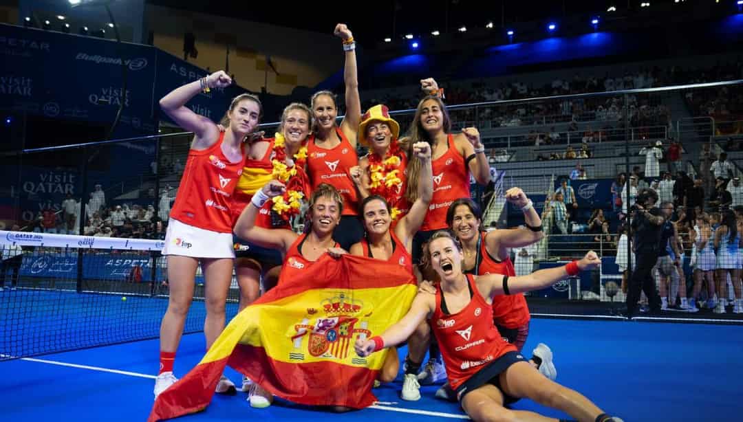 Het Spaanse vrouwenteam viert de wereldtitel padel met de Spaanse vlag op de baan in Qatar