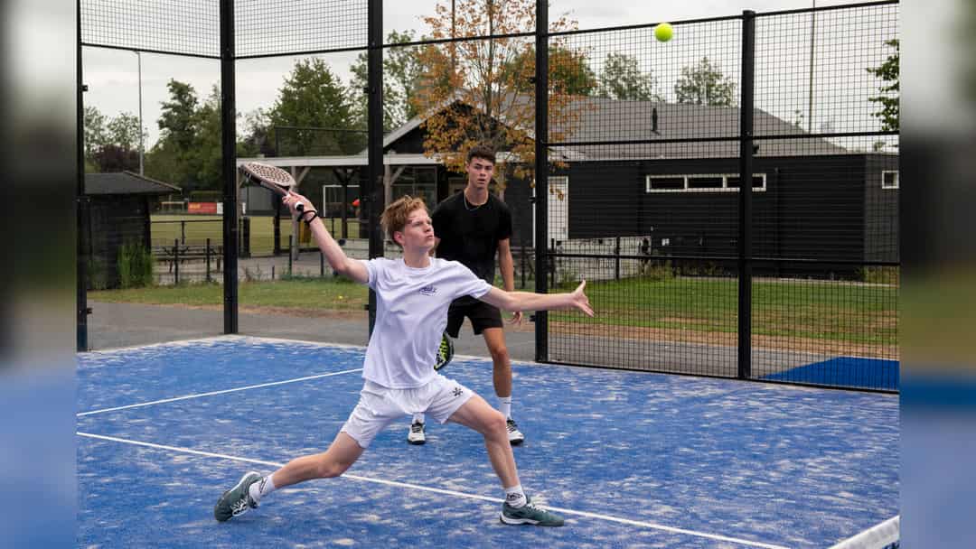 Padelspeler slaat een gestrekte forehand op de buitenbaan van ATV in Alblasserdam