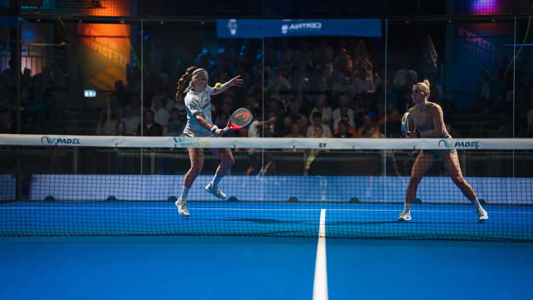 Twee speelsters in actie op de centre court tijdens het EY NK Padel met volle tribune