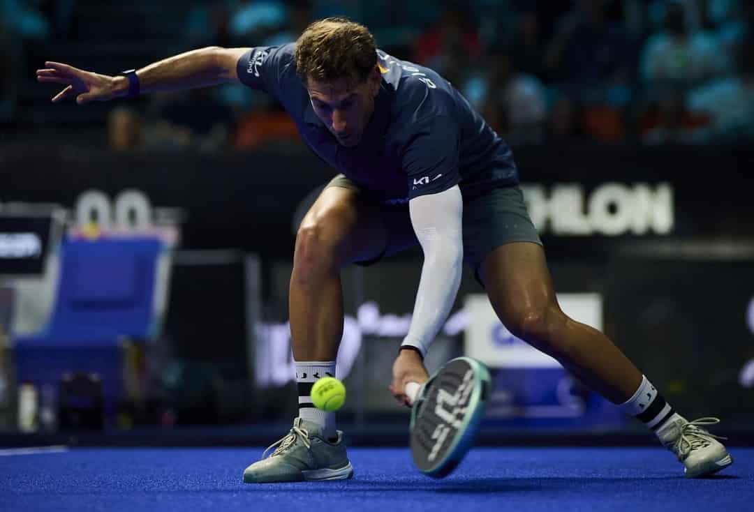 Padelprof strekt zich laag naar de bal tijdens een wedstrijd op de CUPRA FIP Tour