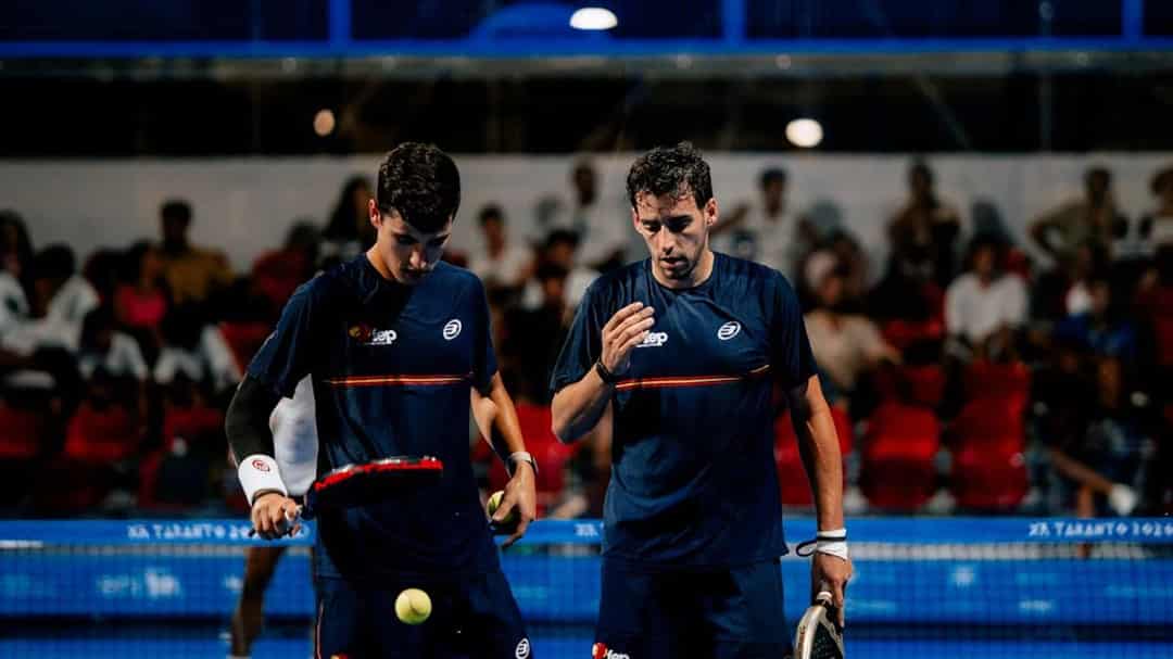 Twee Spaanse padellers overleggen bij het net op de centre court in Taranto